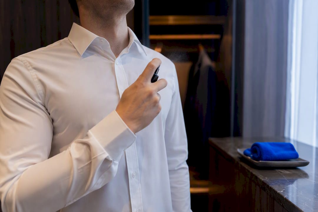 Persona rociando una camisa con atomizador