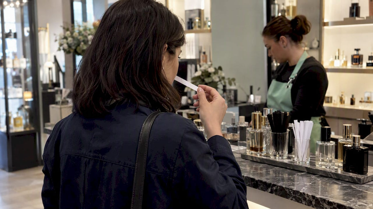 Customer comparing perfumes at a fragrance counter