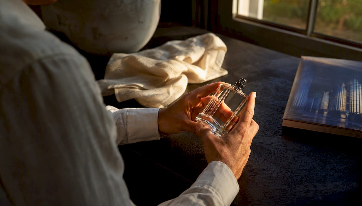 Hands inspecting perfume bottle details