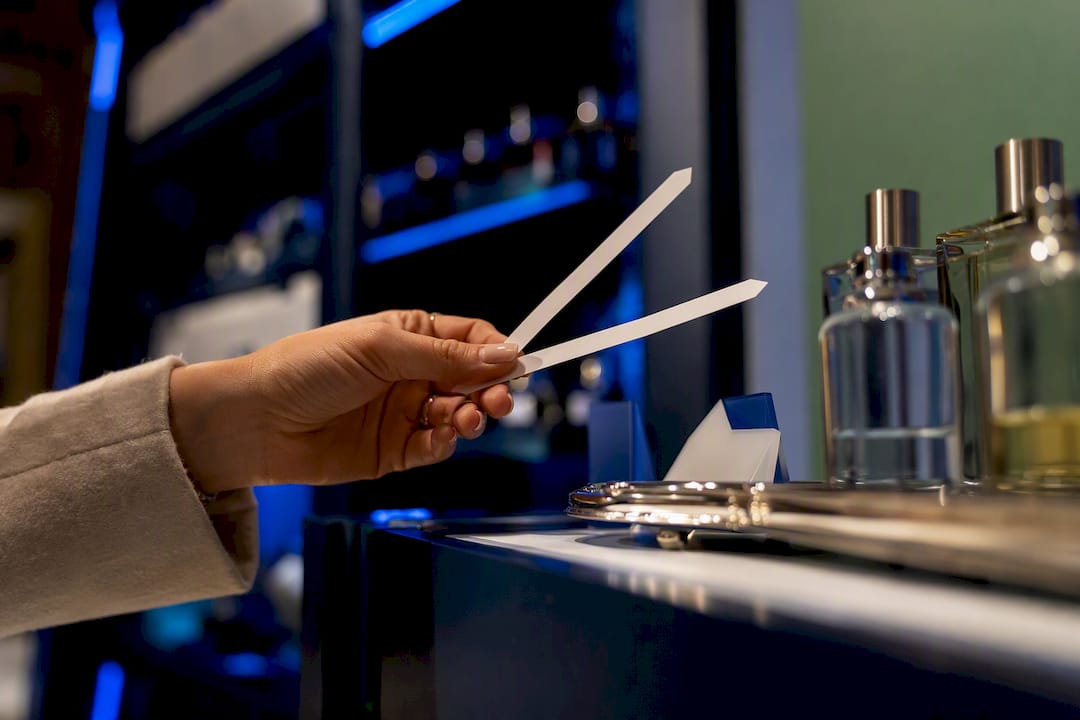 Shopper comparing fragrance testers at sale counter