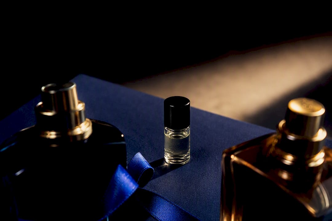 Anonymous fragrance bottles in dramatic navy lighting