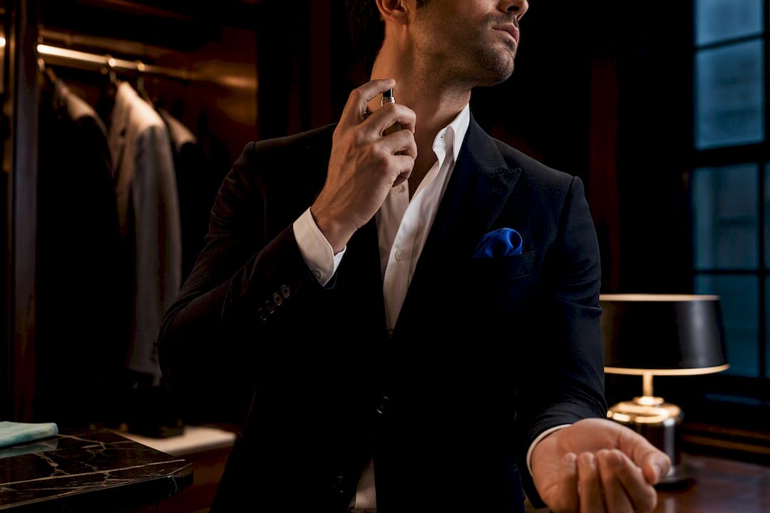Man applying cologne to two pulse points
